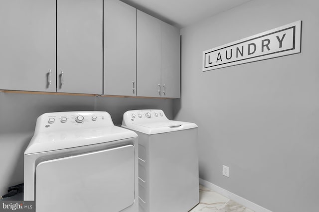 laundry room with baseboards, cabinet space, marble finish floor, and washer and clothes dryer