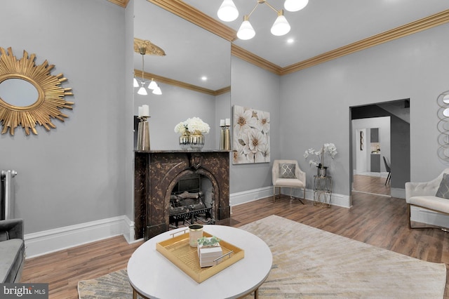 living area featuring wood finished floors, baseboards, a fireplace with flush hearth, and a chandelier