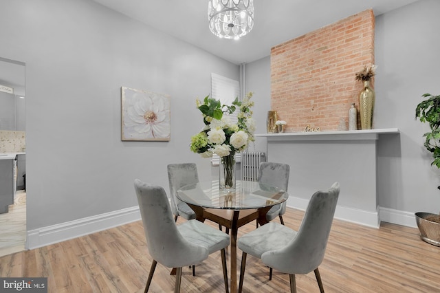 dining room with baseboards, an inviting chandelier, and wood finished floors