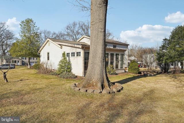 back of property with entry steps and a yard