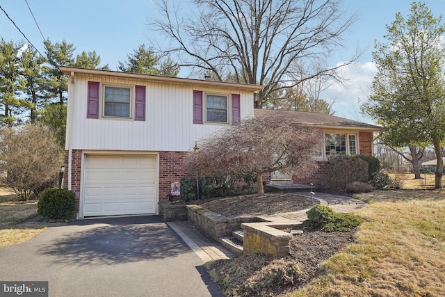 split level home with brick siding, aphalt driveway, and a garage