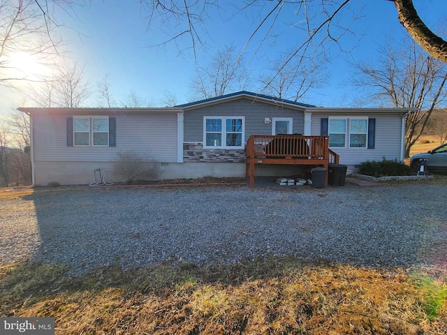 view of front of property with crawl space, stone siding, and a deck