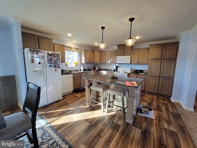 kitchen with dark wood-type flooring, a kitchen island, white appliances, crown molding, and baseboards