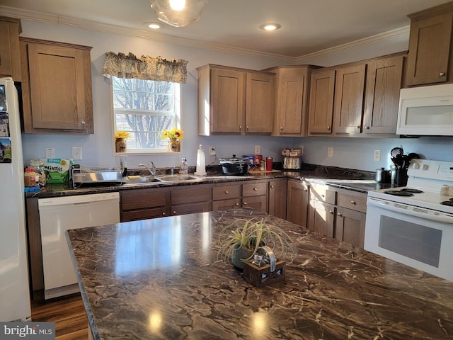 kitchen with dark wood-style flooring, ornamental molding, white appliances, and a sink