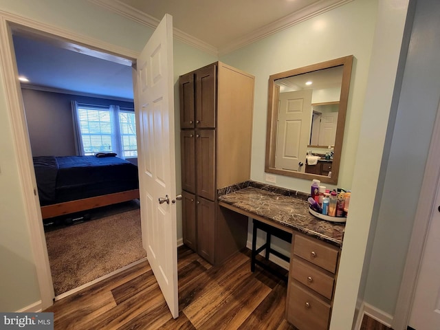 bathroom with vanity, crown molding, baseboards, and wood finished floors