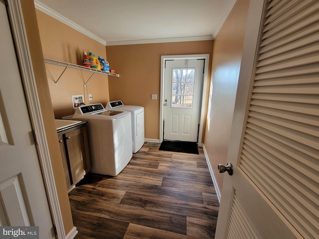 washroom featuring ornamental molding, washer and clothes dryer, dark wood-style floors, cabinet space, and baseboards