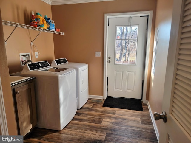 clothes washing area with baseboards, cabinet space, dark wood-style floors, and washer and clothes dryer