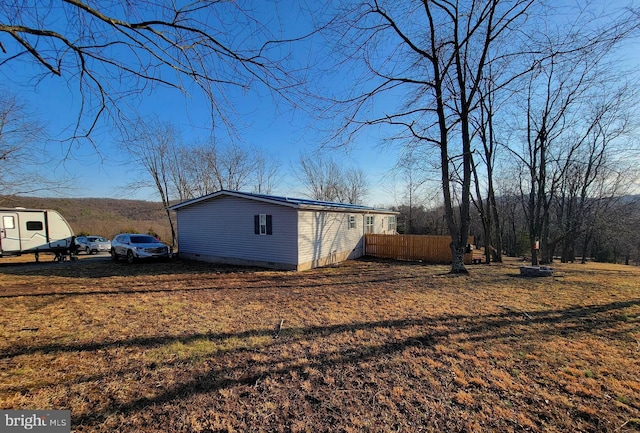 view of property exterior featuring crawl space, a lawn, and fence