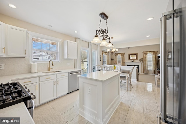 kitchen with a sink, stainless steel appliances, decorative backsplash, and a center island