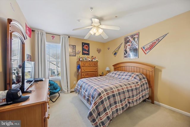 carpeted bedroom with a ceiling fan and baseboards