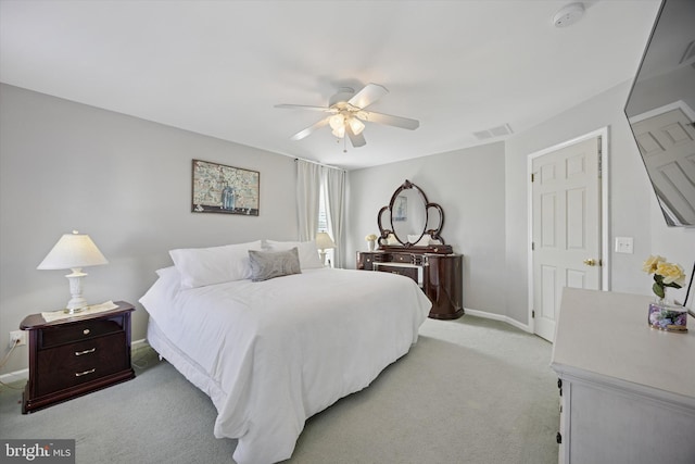 bedroom with light carpet, visible vents, baseboards, and ceiling fan