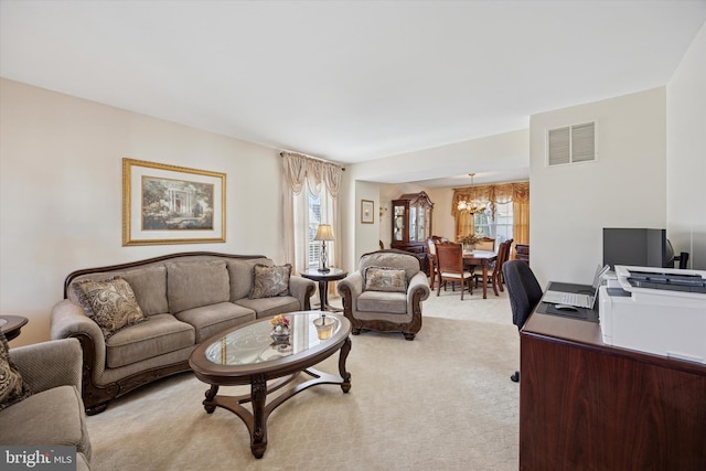 living room with an inviting chandelier, light colored carpet, and visible vents