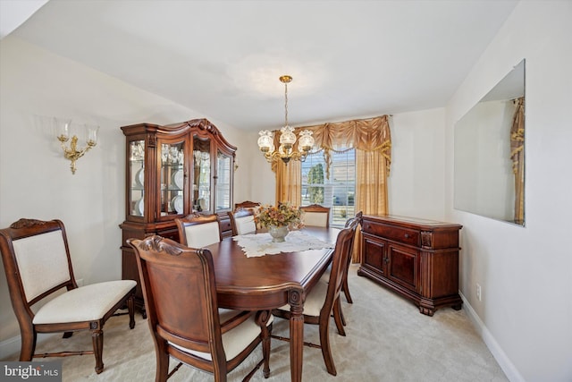 dining area with baseboards, light carpet, and a chandelier