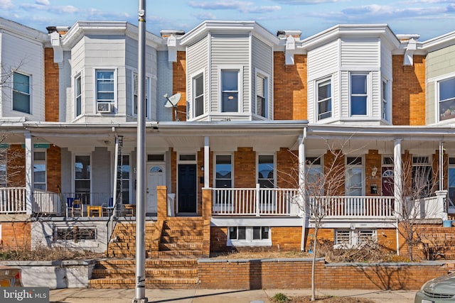 view of property with brick siding and a porch