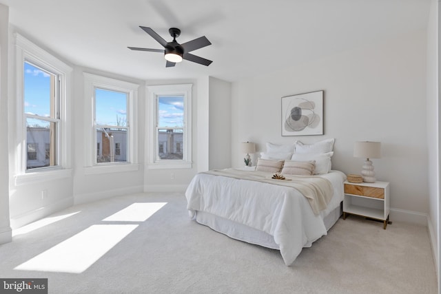 bedroom featuring multiple windows, light colored carpet, and baseboards