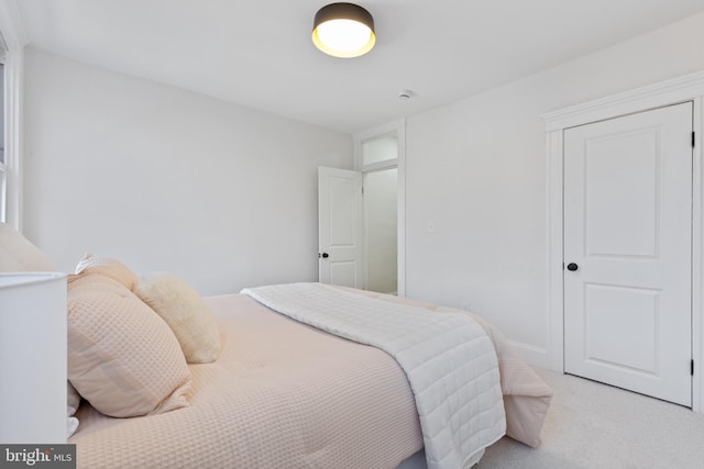 bedroom with baseboards and light carpet