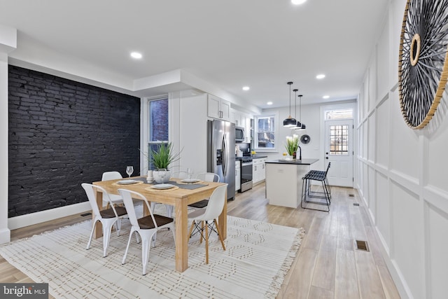 dining room with recessed lighting, visible vents, baseboards, and light wood-style floors