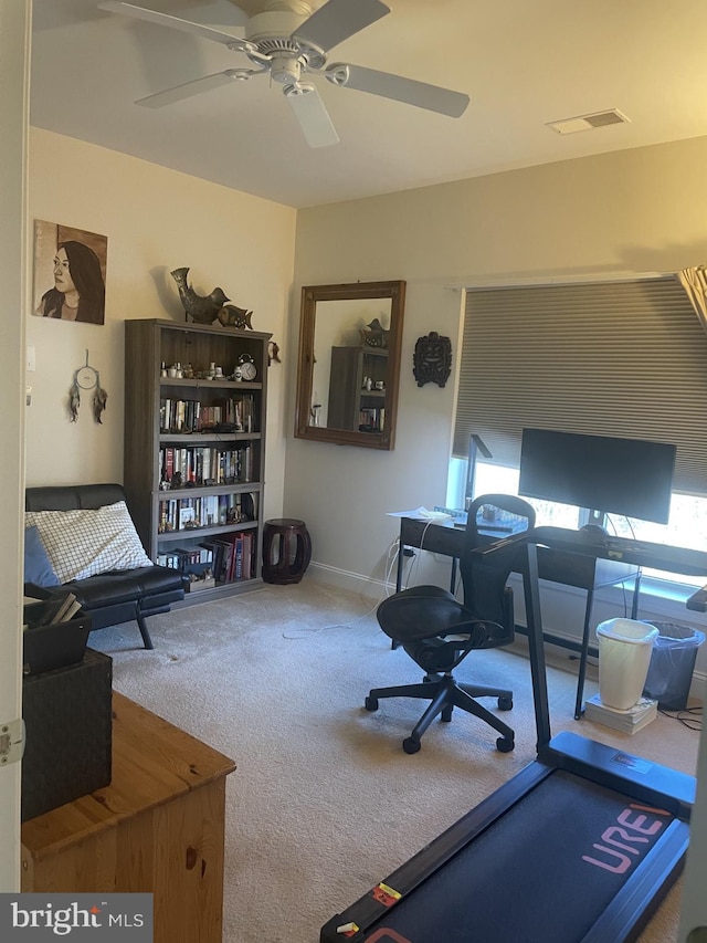 carpeted office space featuring visible vents, baseboards, and a ceiling fan