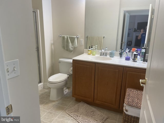 bathroom featuring tile patterned floors, toilet, a stall shower, and vanity