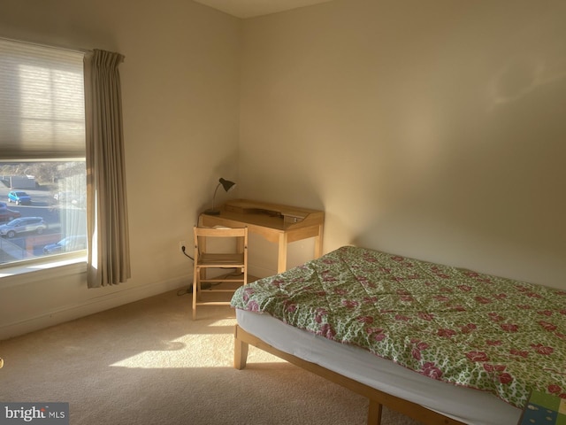 carpeted bedroom featuring multiple windows and baseboards