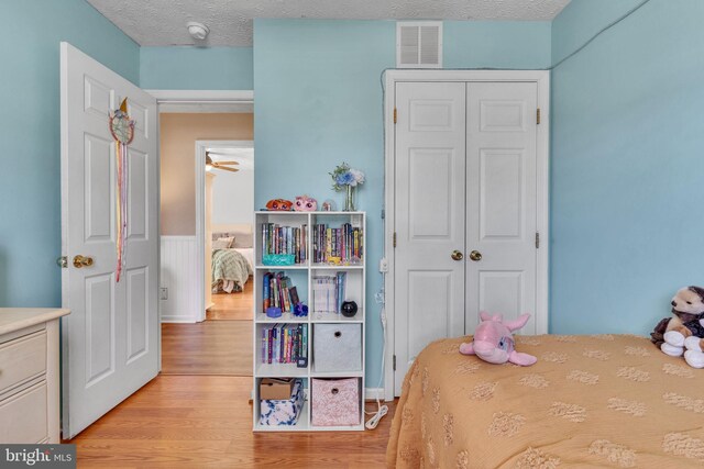 bedroom with visible vents, a textured ceiling, a closet, and light wood-style flooring