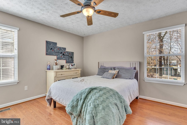 bedroom featuring wood finished floors, visible vents, and baseboards