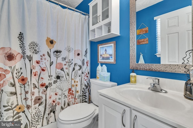 bathroom with a shower with shower curtain, toilet, and vanity