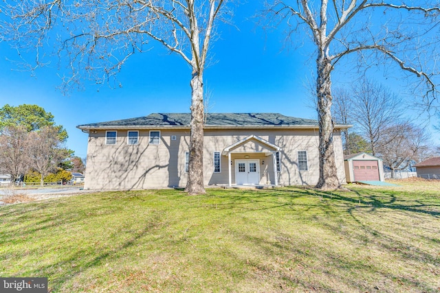 view of front of house featuring a garage, french doors, an outdoor structure, and a front yard