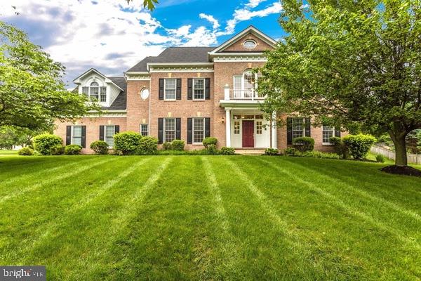 georgian-style home featuring brick siding and a front lawn