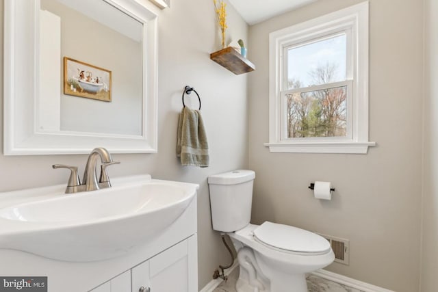 bathroom with vanity, toilet, baseboards, and visible vents