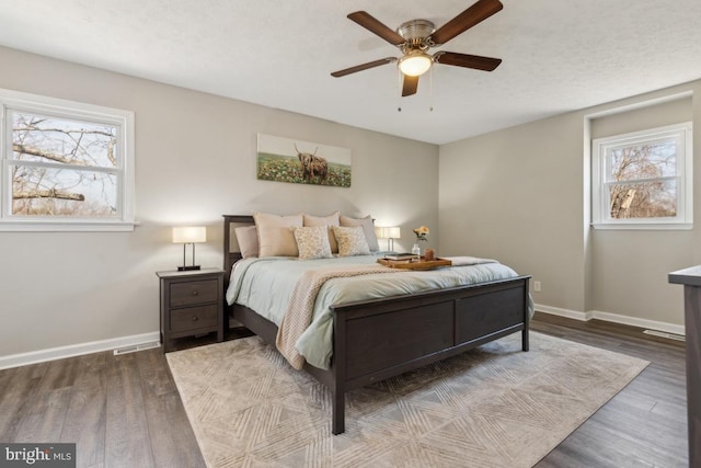 bedroom featuring ceiling fan, baseboards, and wood finished floors