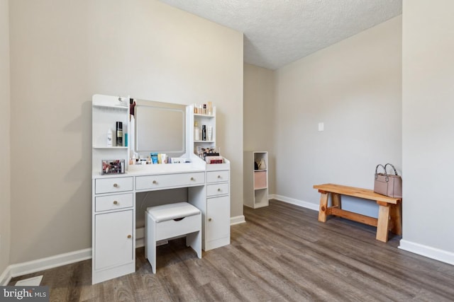 office featuring baseboards, a textured ceiling, and wood finished floors