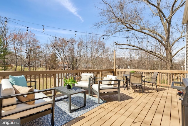 wooden terrace with an outdoor living space