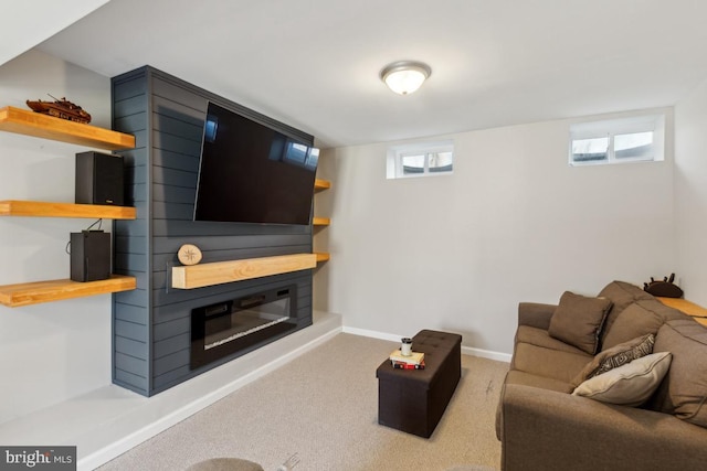 carpeted living room featuring baseboards and a glass covered fireplace