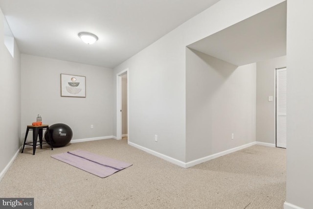 workout room featuring baseboards and carpet