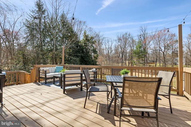 wooden deck with outdoor dining space and an outdoor hangout area