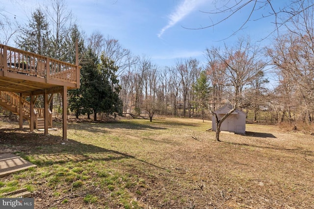 view of yard featuring a deck, a storage shed, an outdoor structure, and stairs