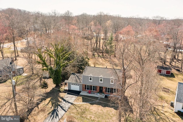 birds eye view of property featuring a view of trees