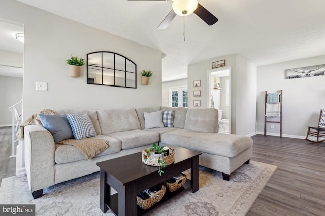 living area with a ceiling fan, baseboards, and wood finished floors