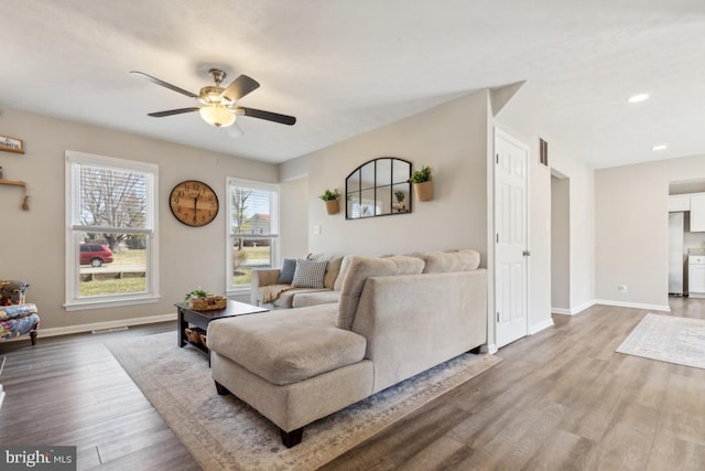 living area featuring recessed lighting, a ceiling fan, baseboards, and wood finished floors