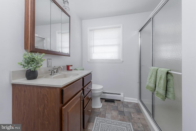 bathroom with a baseboard heating unit, a stall shower, vanity, and stone finish floor