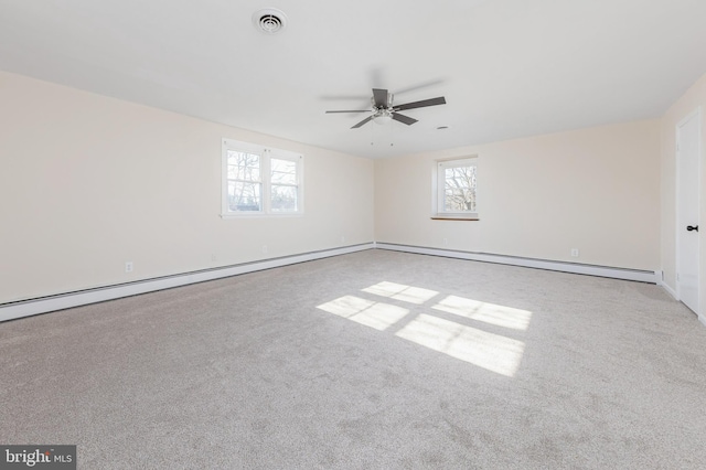 spare room with a baseboard heating unit, carpet, visible vents, and ceiling fan