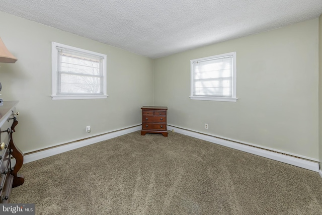 unfurnished room with a baseboard heating unit, carpet, and a textured ceiling