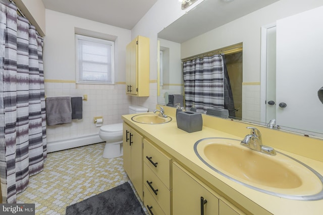 bathroom featuring a sink, a baseboard radiator, toilet, and tile walls