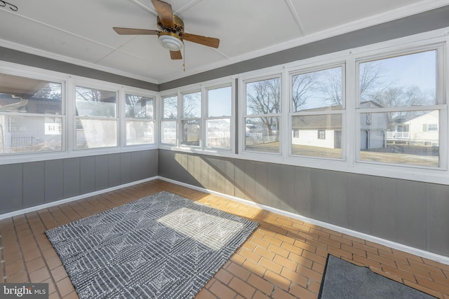 unfurnished sunroom with ceiling fan