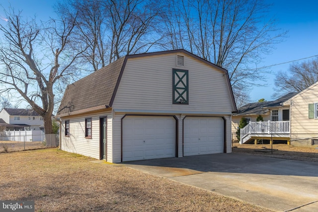 garage featuring a detached garage and fence