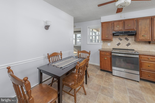 kitchen with stainless steel range with electric stovetop, tasteful backsplash, brown cabinets, and under cabinet range hood