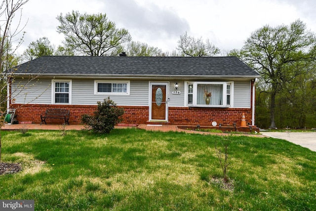 ranch-style house with roof with shingles, brick siding, and a front lawn