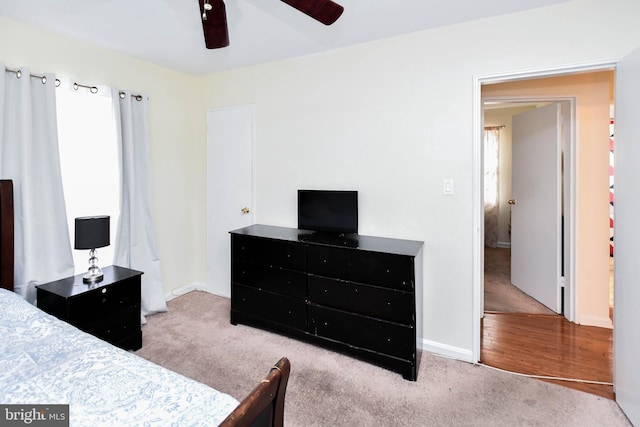 carpeted bedroom with ceiling fan and baseboards