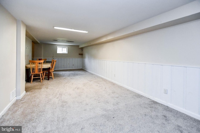 basement with carpet flooring, wainscoting, and visible vents